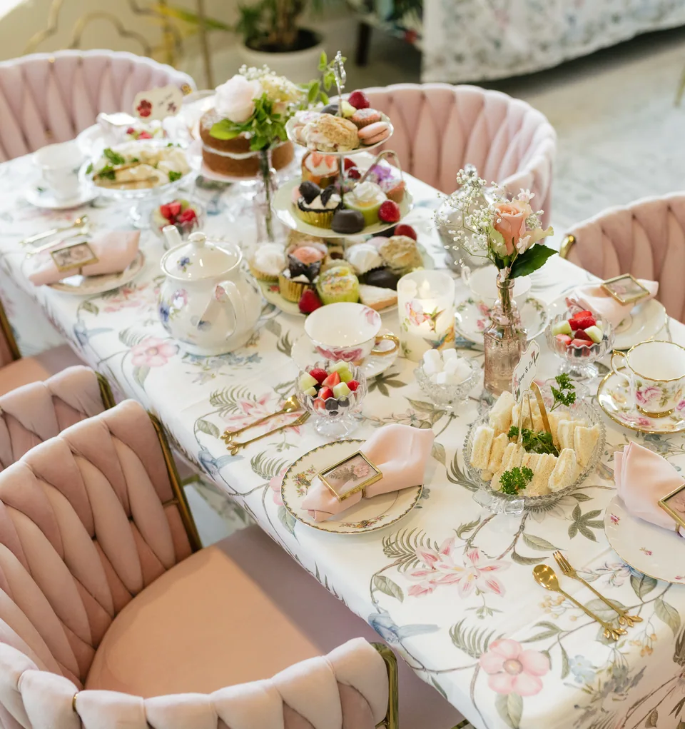 Fine floral china, pink linens, flowers, and a beautifully set tea table